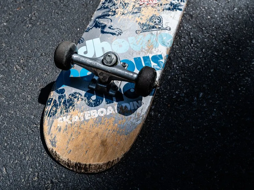 A graphic skateboard deck lying on asphalt