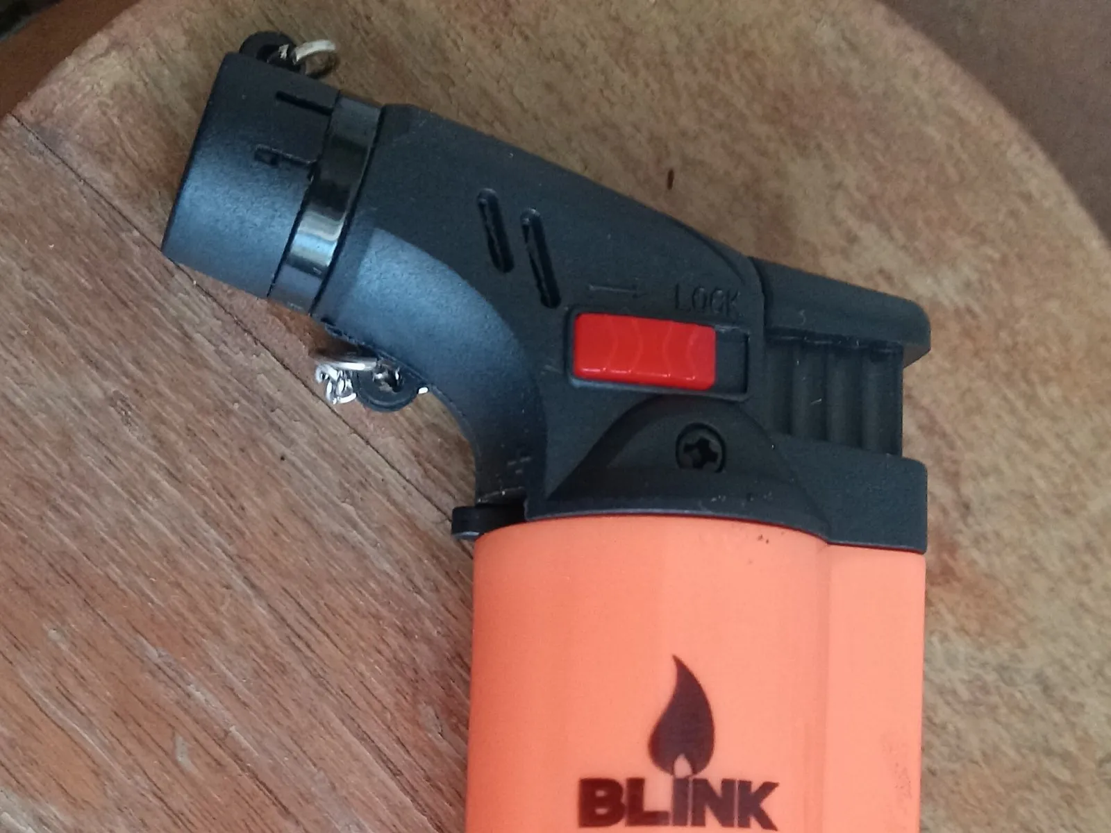 An orange refillable butane torch lighter with an angled nozzle